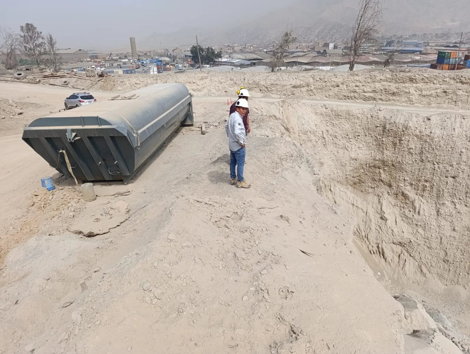 Tanque enterrado en excavación con un ingeniero supervisando la obra en la cantera